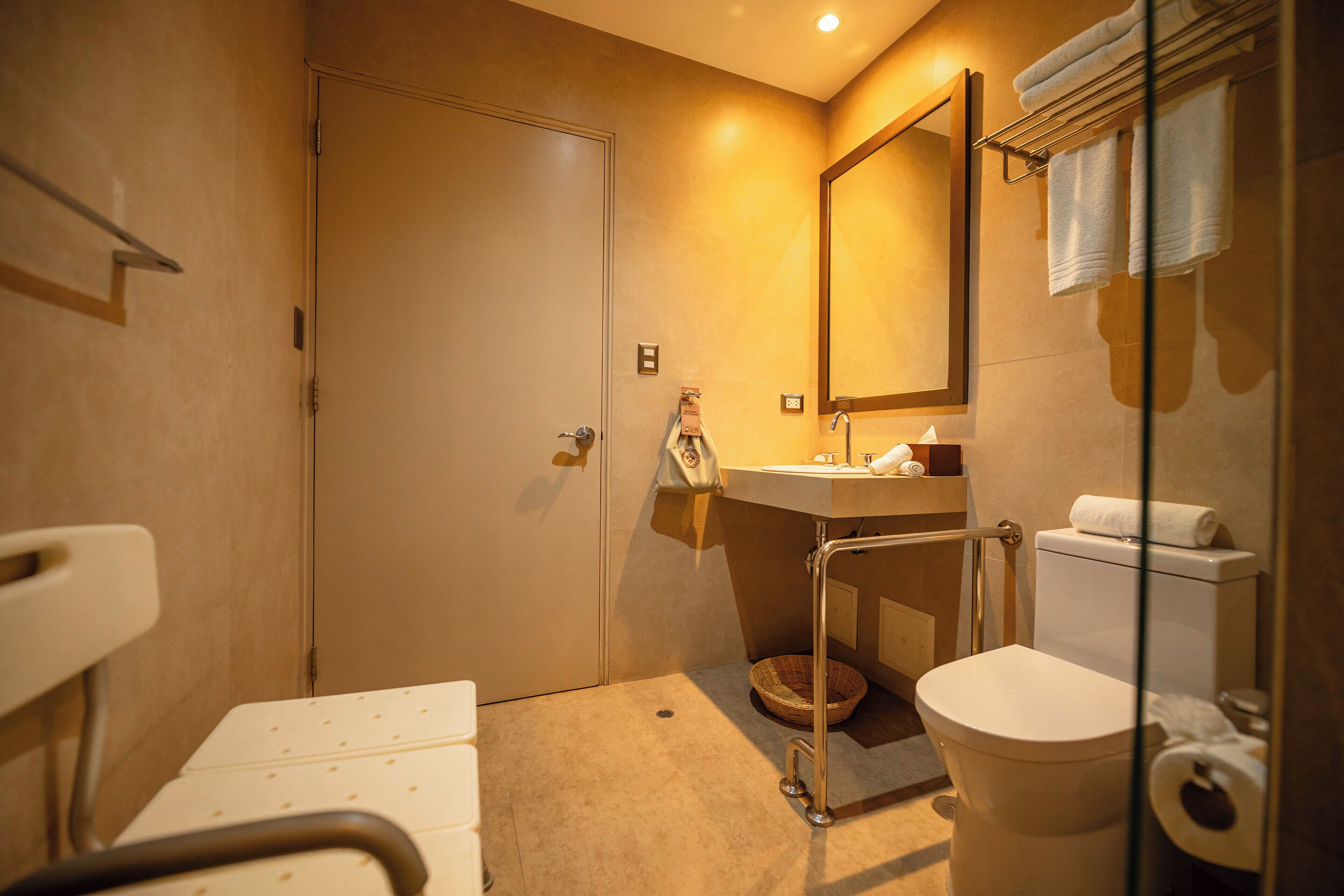 A compact bathroom with a toilet, sink, and mirror.