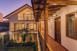 A two-story building with balconies, a covered walkway, and a garden area. - Saska Boutique (Cusco)