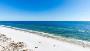 A beach with clear blue water and white sand.