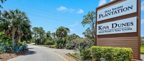 Une route menant à un panneau indiquant l’accès à Gulf Shores Plantation et au complexe hôtelier et terrain de golf Kiva Dunes Beach Resort.