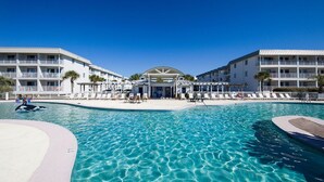 Un hotel con una grande piscina, diversi balconi e una zona coperta al centro.
