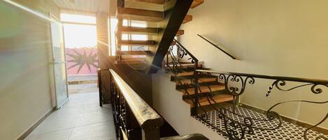 Una escalera de madera con barandilla metálica.