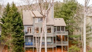 A multi-story house with a balcony on the second floor and a staircase leading to the third floor. - Lake's Edge Lodge - Water Views, & Community Golf! (Big Canoe)