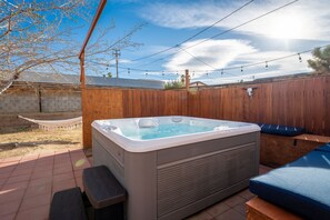 A hot tub with a wooden fence and a hammock in the background. - Tortoise Oasis - Hot tub, Shuffleboard, & More! (Yucca Valley)