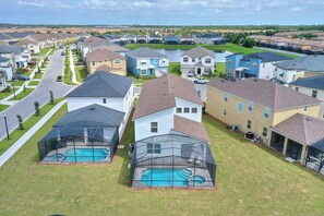 A residential area with houses, a swimming pool, and a covered patio area. - Private Pool, Spa and Premium Resort Amenities Included! (Kissimmee)