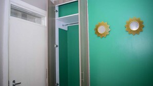 A bathroom with a green wall, a white door, and two gold-framed mirrors.