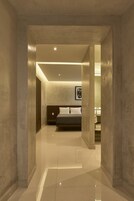Una habitación de hotel moderna con una cama grande, una mesita de noche y un cuadro enmarcado en la pared.