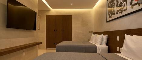 A modern hotel room with a flat-screen TV, two beds, wooden wardrobe, and a large abstract painting.