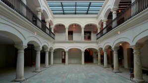 A spacious courtyard with a central open area, surrounded by arches and columns, and a glass ceiling above. - Casa Quiote Hotel Boutique City Center based - Adults Only (Oaxaca)