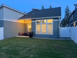 A residential backyard with a patio area, a grill, and string lights. - Modern Townhome- downtown Coeur d'Alene- minutes to waterfront restaurants shops (Coeur d'Alene)