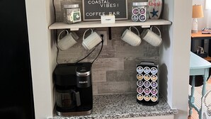 Une cuisine équipée d’un coin café, d’une bouilloire, de tasses et d’une pancarte indiquant « 19, avenue Perry ».