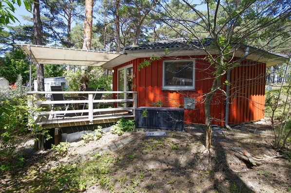 A small red cabin with a white deck and a window. - Vacation home Tipi 365 - vacation home near the beach with terrace - Holiday home Tipi (Göhren)