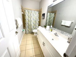 A bathroom with a toilet, sink, and mirror.