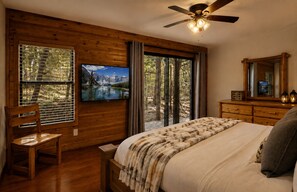 Ein Schlafzimmer mit Bett, Sessel, Fernseher, Deckenventilator und Kommode.