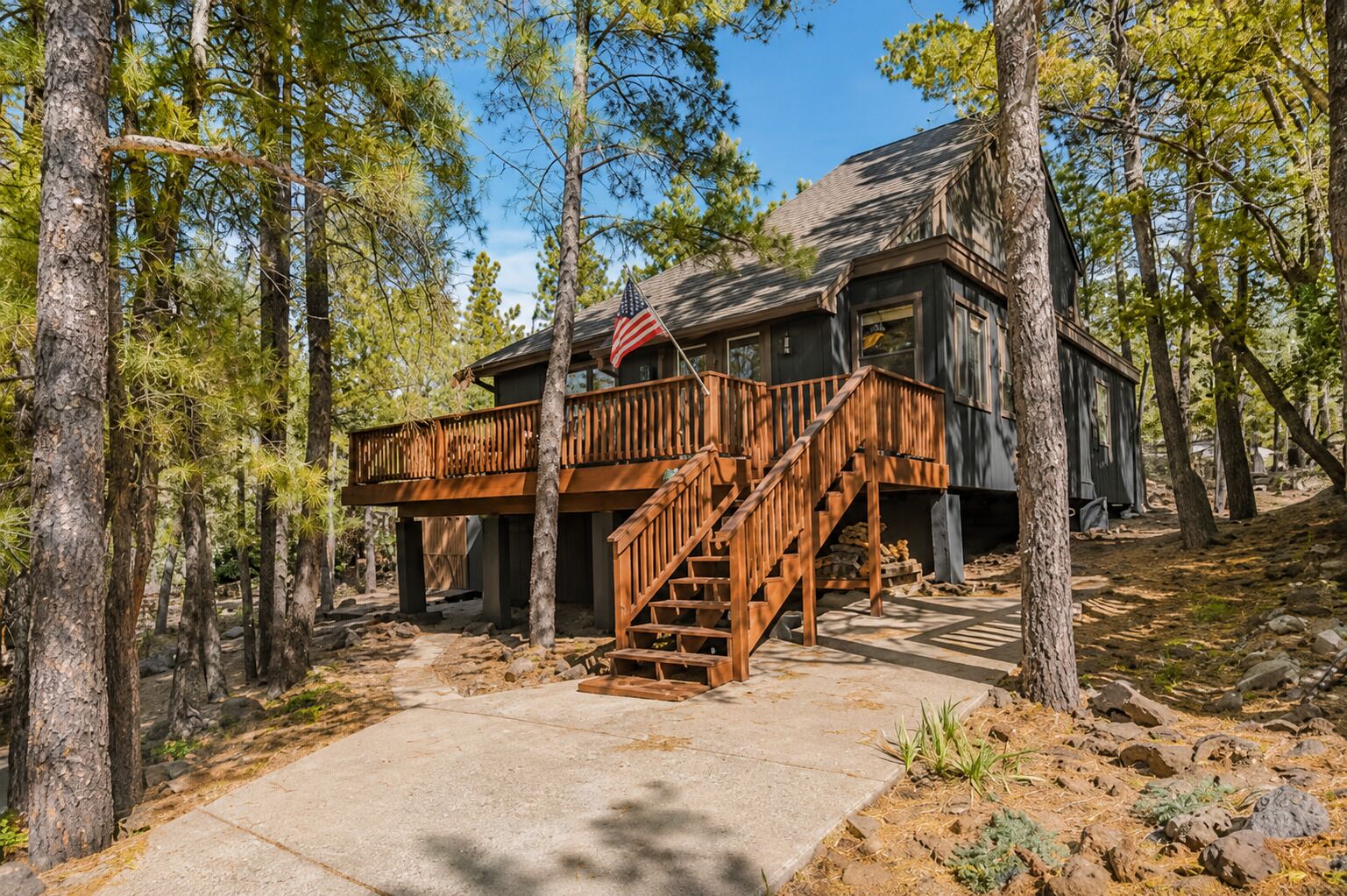 Eine Holzhütte mit einer Holzterrasse und einer Treppe zum Eingang.