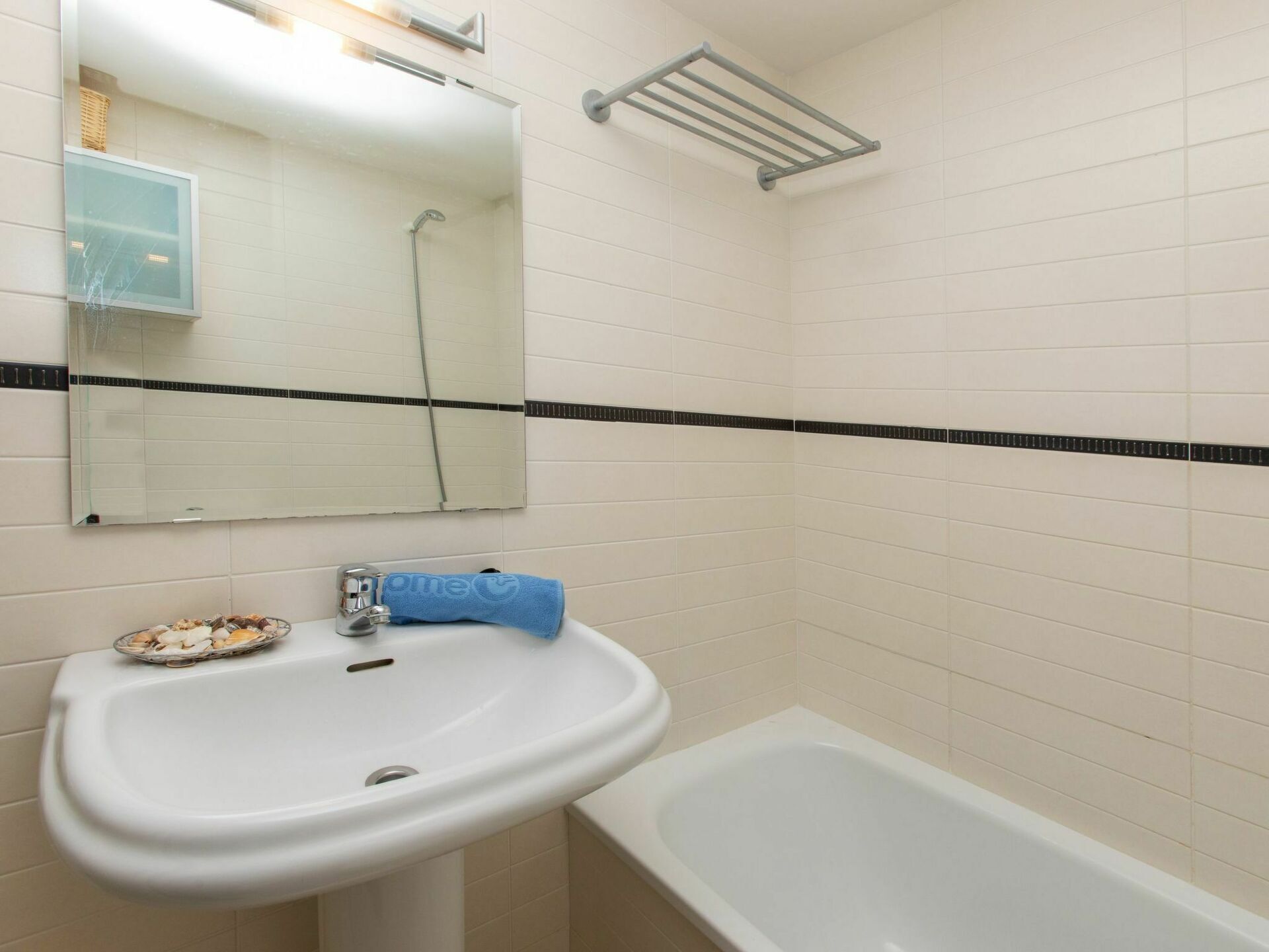 A bathroom with a white sink, a mirror, and a bathtub.