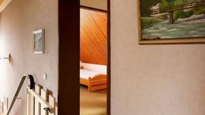 A hotel room with a bed, a painting, and a staircase. - (STOE3) Holiday apartment "Waack" - Holiday apartment "Waack" up to 4 persons (Timmendorfer Strand)