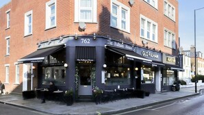 The Fulham House, een pub met terras en een zwart gevel.