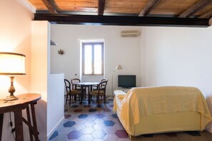 A room with a bed, a desk, a chair, a table, and a television. - Stay in Rome Apartments Sunny Navona Sq. (Roma)