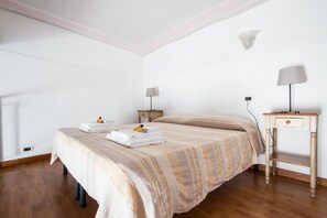 A bedroom with a bed, bedside tables, lamps, and a wooden floor. - Stay in Rome Apartments Sunny Navona Sq. (Roma)