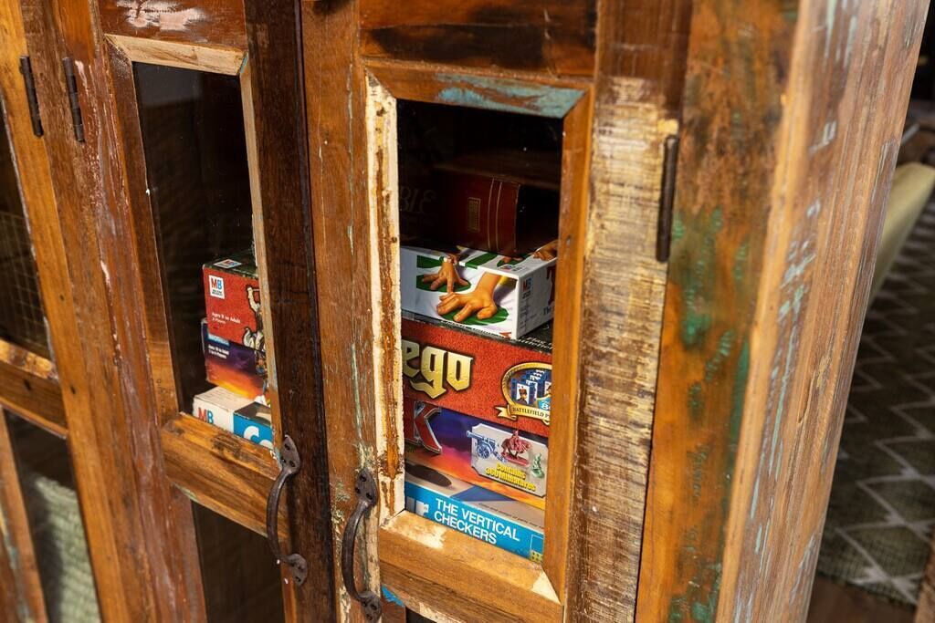 Un meuble en bois doté de deux compartiments à façade en verre, chacun contenant une boîte de jeu.
