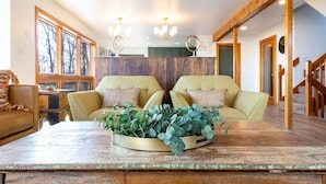 Een gezellige kamer met twee banken die een houten salontafel met een plant in het midden frontaal bestrijken.