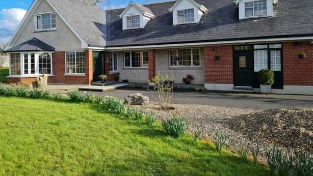 A two-story house with a brick facade, a black roof, and a front porch. - 1 Bed retreat-Sleeps 2-Secure parking-Garden (Ennis)