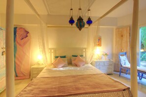 Une chambre à coucher avec un grand lit, une table de chevet, une lampe et un tableau au mur.