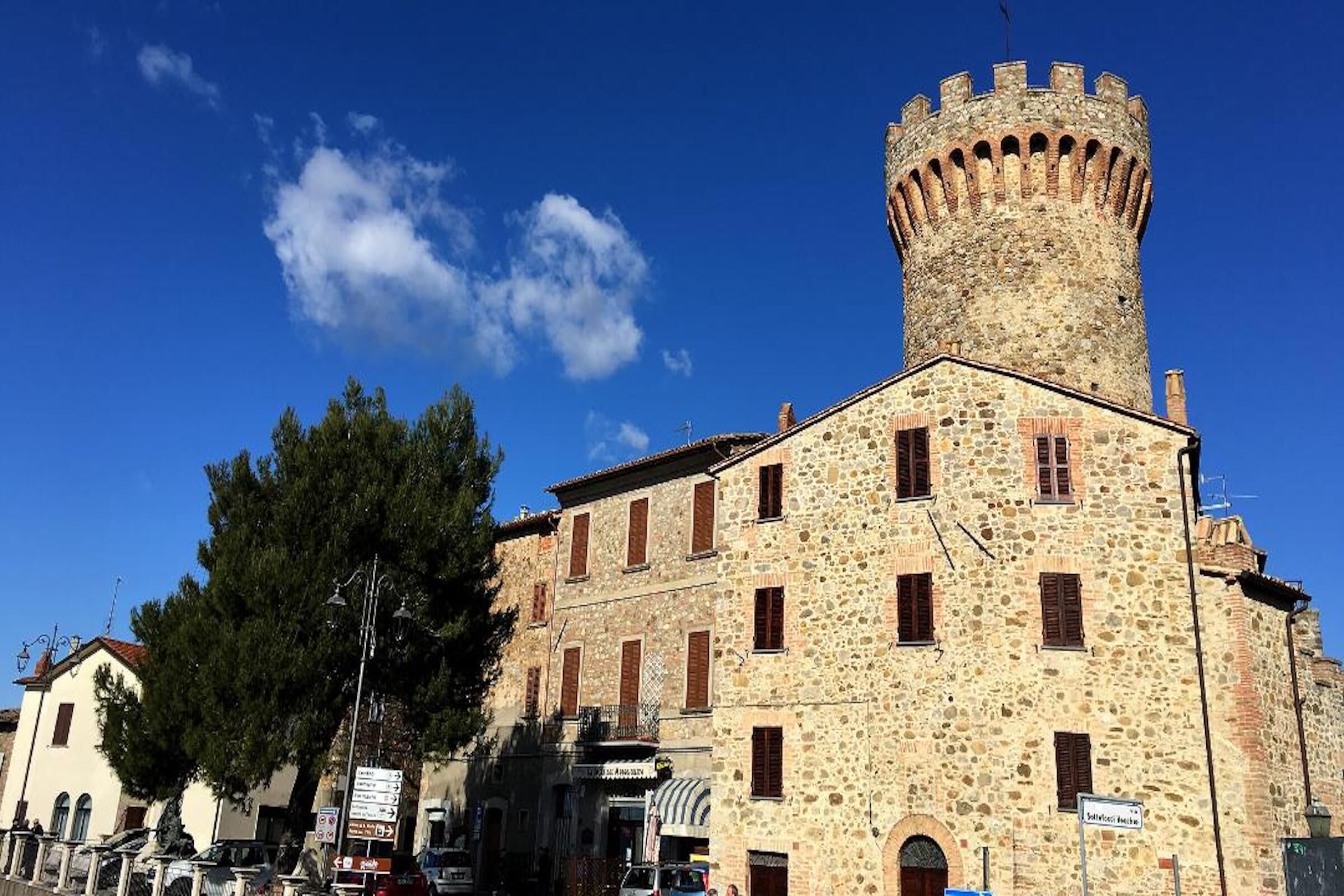 Un edificio storico in pietra con una torre imponente e numerose finestre.