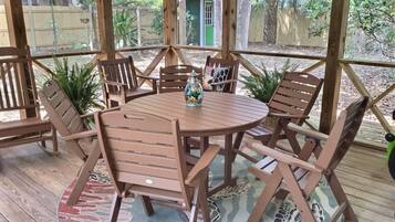 Enjoy al fresco dining on the deck with a round table and six chairs, surrounded by lush greenery.