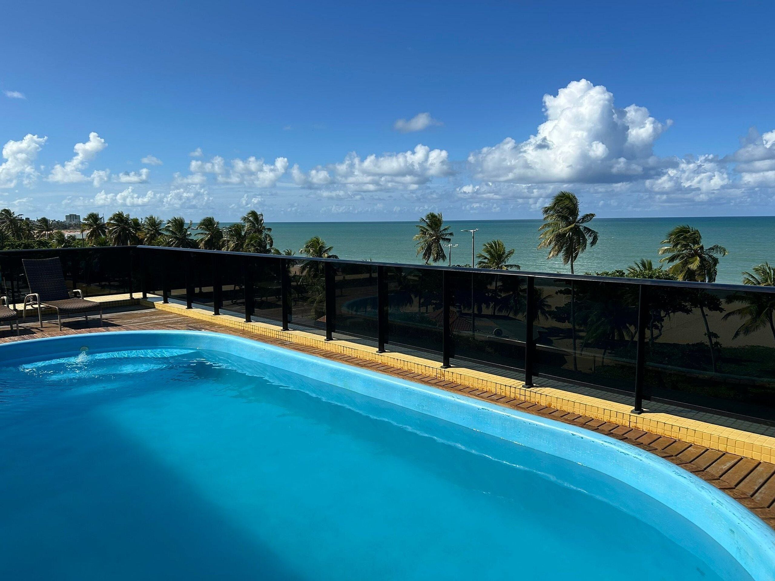 Una piscina con vista al océano y palmeras.