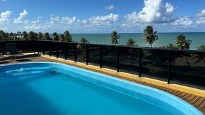 Una piscina con vista al océano y palmeras.