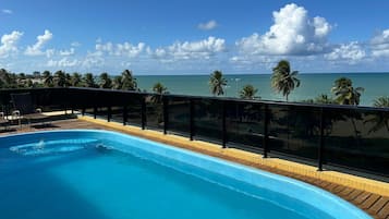 Una piscina con vista al océano y palmeras.