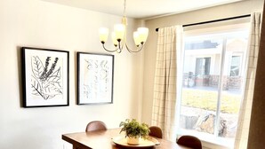 A dining area with a wooden table, bench seating, a chandelier, and framed artwork on the wall. - Beautiful Townhouse Retreat walking distance to shakes! (Garden City)