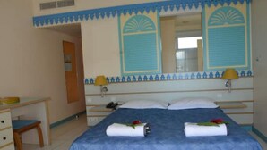 Habitació d'hotel amb llit, escriptori i cadira.