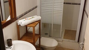 A bathroom with a sink, toilet, and glass-enclosed shower.