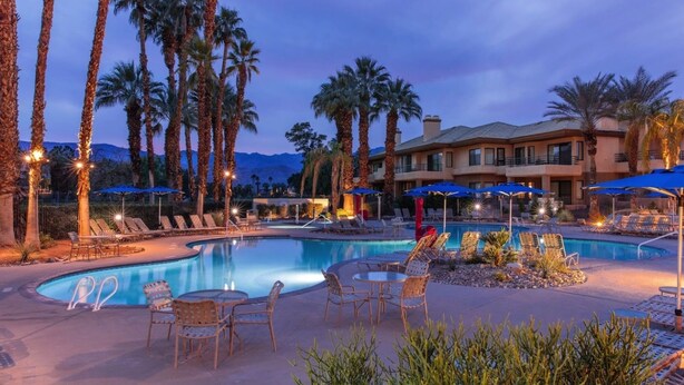A resort pool area with lounge chairs, umbrellas, and a building in the background. - Marriott Desert Springs I Studio (Palm Desert)