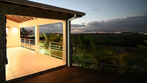Ein geräumiger Balkon mit Blick auf eine Stadtlandschaft im Abenddämmerung.