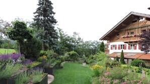 Un sentier de jardin menant à un bâtiment en bois doté d’un balcon.