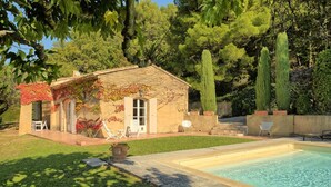 A house with a swimming pool, a patio with chairs, and a garden with trees. - Sunny holiday home in Provence with pool (Séguret)