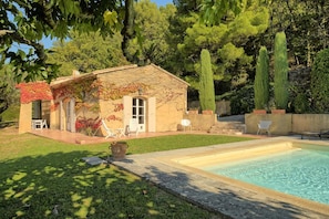 A house with a swimming pool, a patio with chairs, and a garden with trees. - Sunny holiday home in Provence with pool (Séguret)