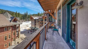 A balcony with a view of a ski resort, wooden railings, and a snow-covered ground. - Big Horn Lodge 501 - Luxury Two Bedroom (Truckee)