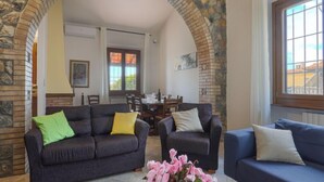 Ein gemütliches Wohnzimmer mit zwei Sofas, einem Couchtisch und einem steinernen Bogen.