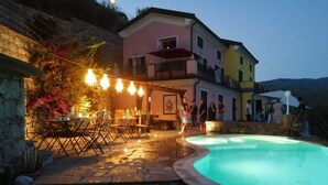 A poolside area with a stone patio, outdoor seating, and a pool. - Holiday Apartment "Villa Lice - Coronata" with Mountain View, Shared Pool & Wi-Fi (casarza ligure)