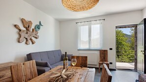 A modern living room with a wooden table, a sofa, and a view of a balcony. - Holiday Apartment "Villa Lice - Coronata" with Mountain View, Shared Pool & Wi-Fi (casarza ligure)