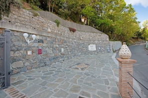 A stone pathway leading to a stone wall with a sign reading 'Villa Loco.'