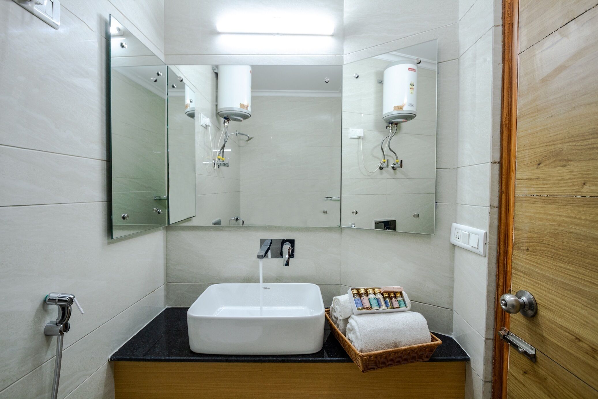 A bathroom with a white sink, a mirror, a towel rack, and a shower head.