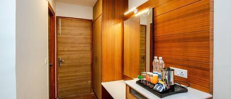 A modern bathroom with wooden cabinetry, a countertop with toiletries, and a mirror.