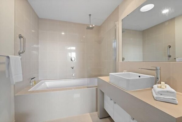 Ein modernes Badezimmer mit Badewanne, Waschbecken und einem großen Spiegel.