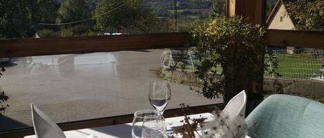 A table set for two with a view of a rural landscape.